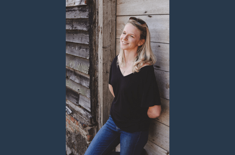 Bridebook.co.uk Bryony leaning against wooden wall