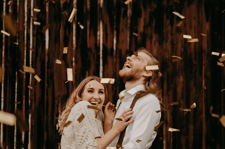 Bridebook.co.uk metallic confetti over bride and groom 