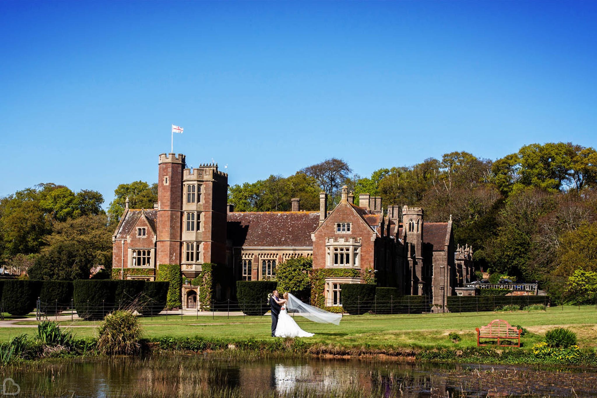 a couple dances outside their wedding venue in front of a lake