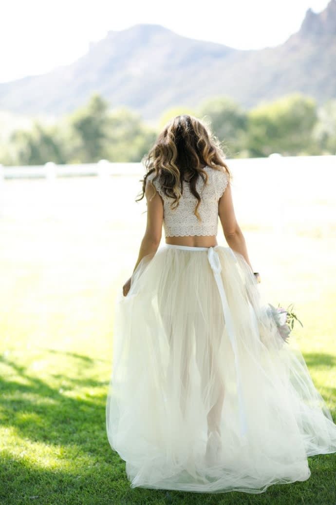 bridebook.co.uk bride walking in a field in a two piece wedding outfit