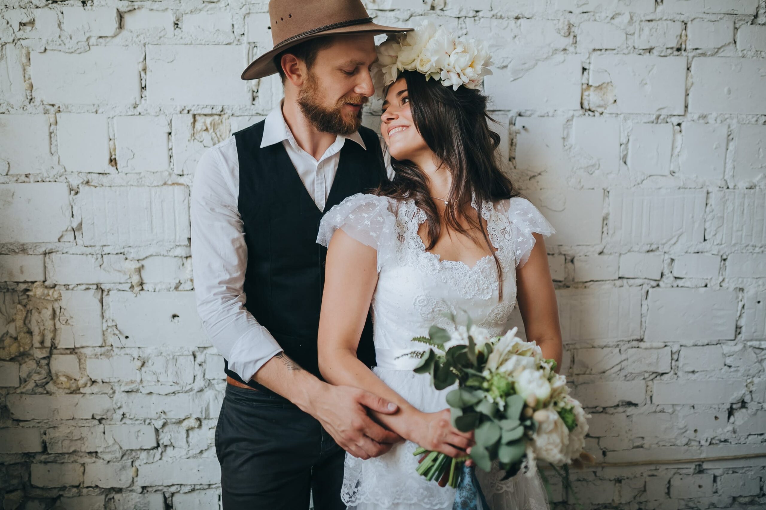 Bridebook.co.uk bride and groom in front of white wall