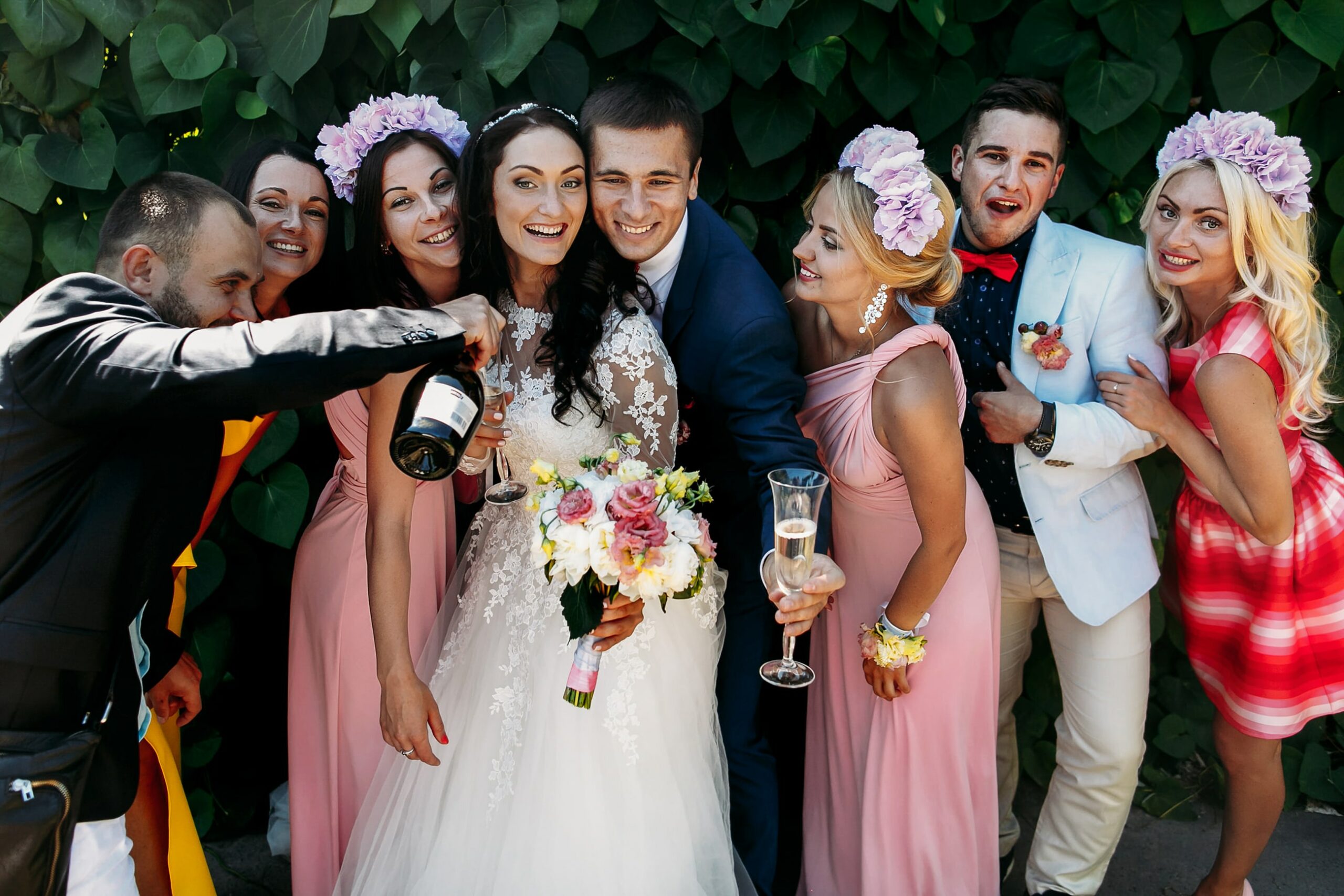 Bridebook.co.uk guests pouring champagne with happy couple