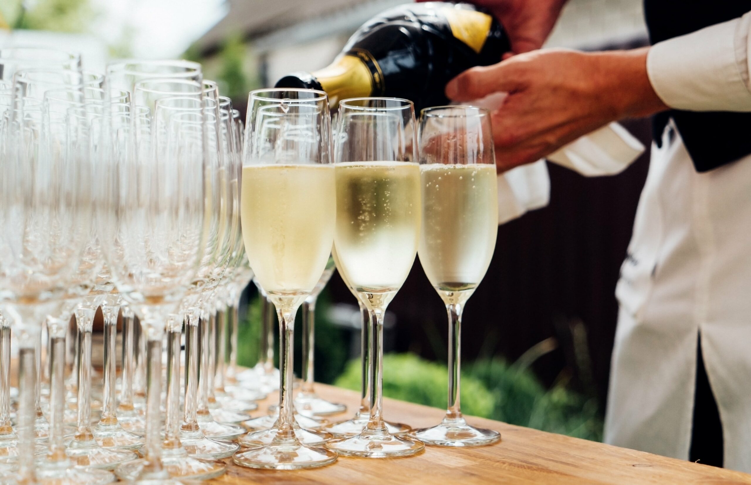 Bridebook.co.uk Waiter pouring glasses of champagne waiting for guests to arrive