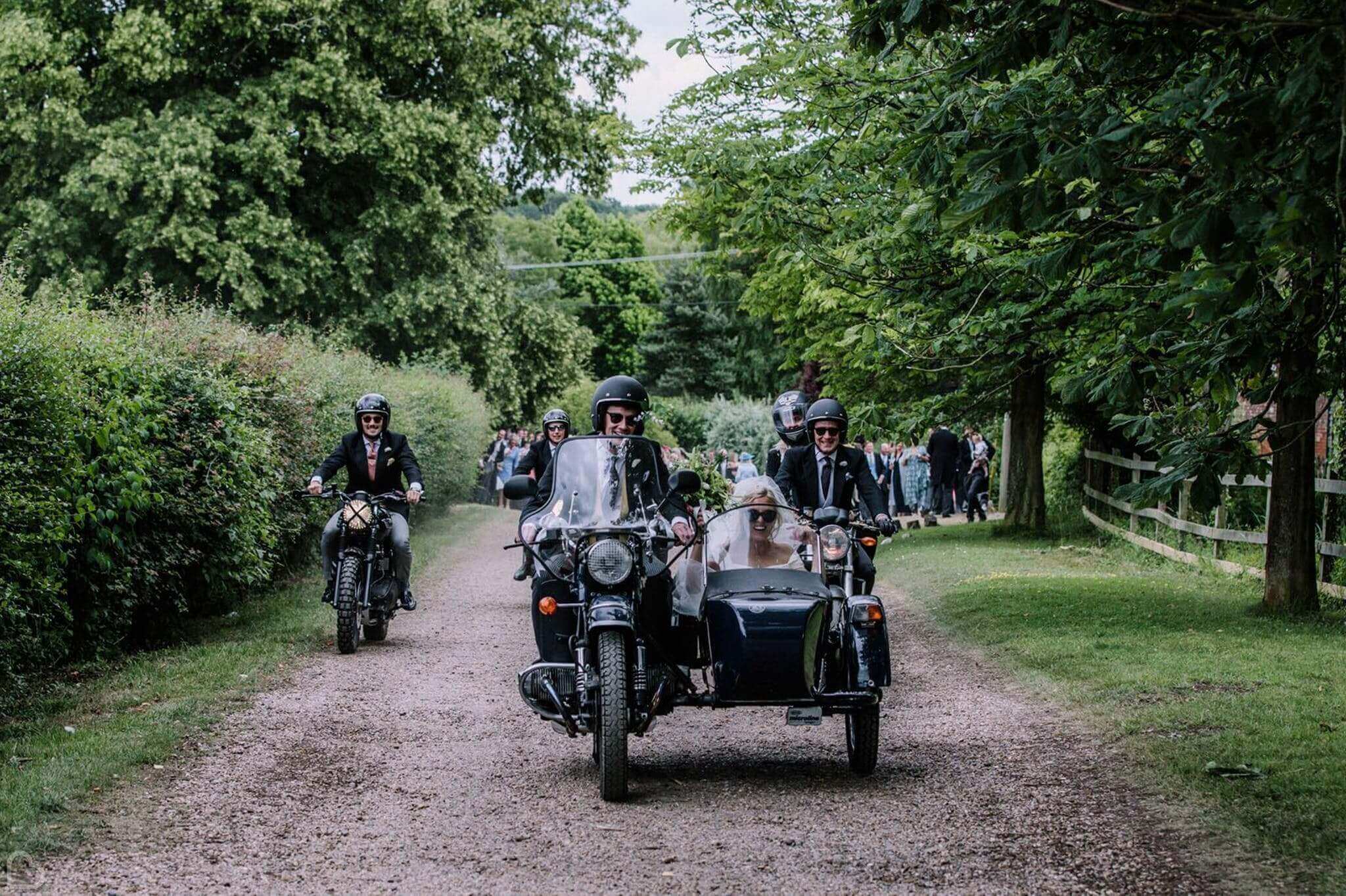 bowhayes farm wedding party rolling in on moterbikes, with bride in the sidecar